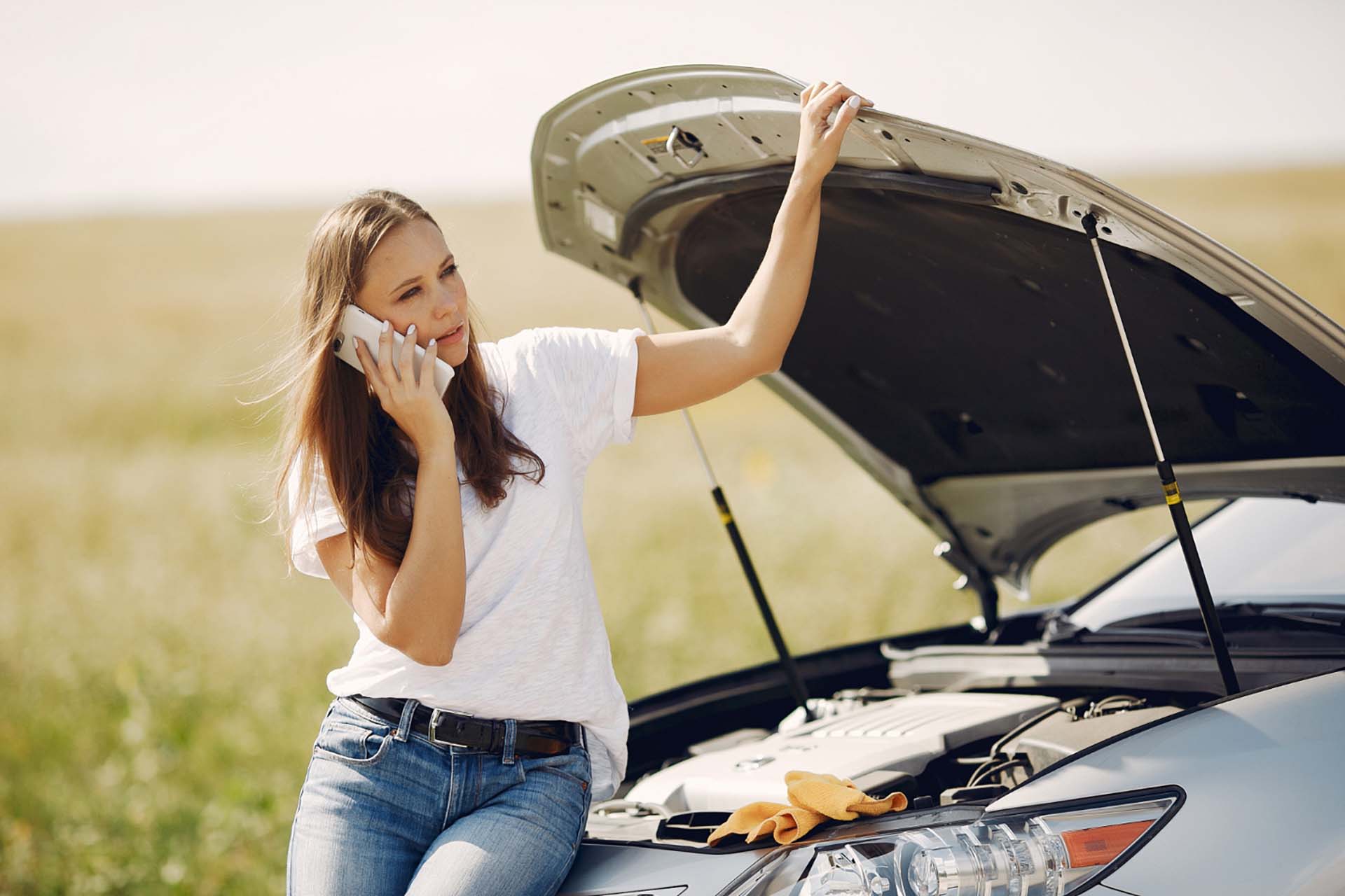 a woman wonder why car won't start and calling for help