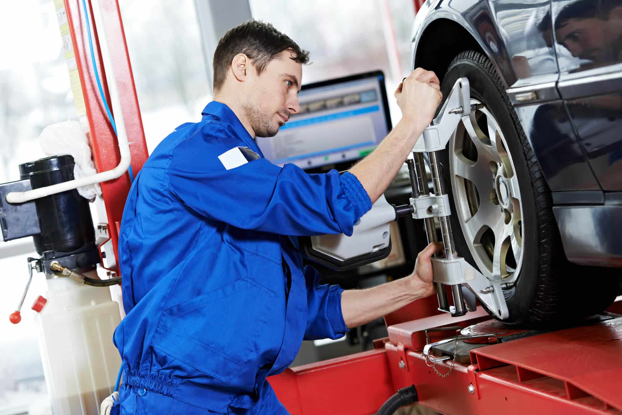 an auto mechanic fixing bad wheel alignment