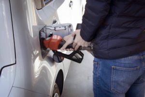 a man refilling as silver vehicle with gas