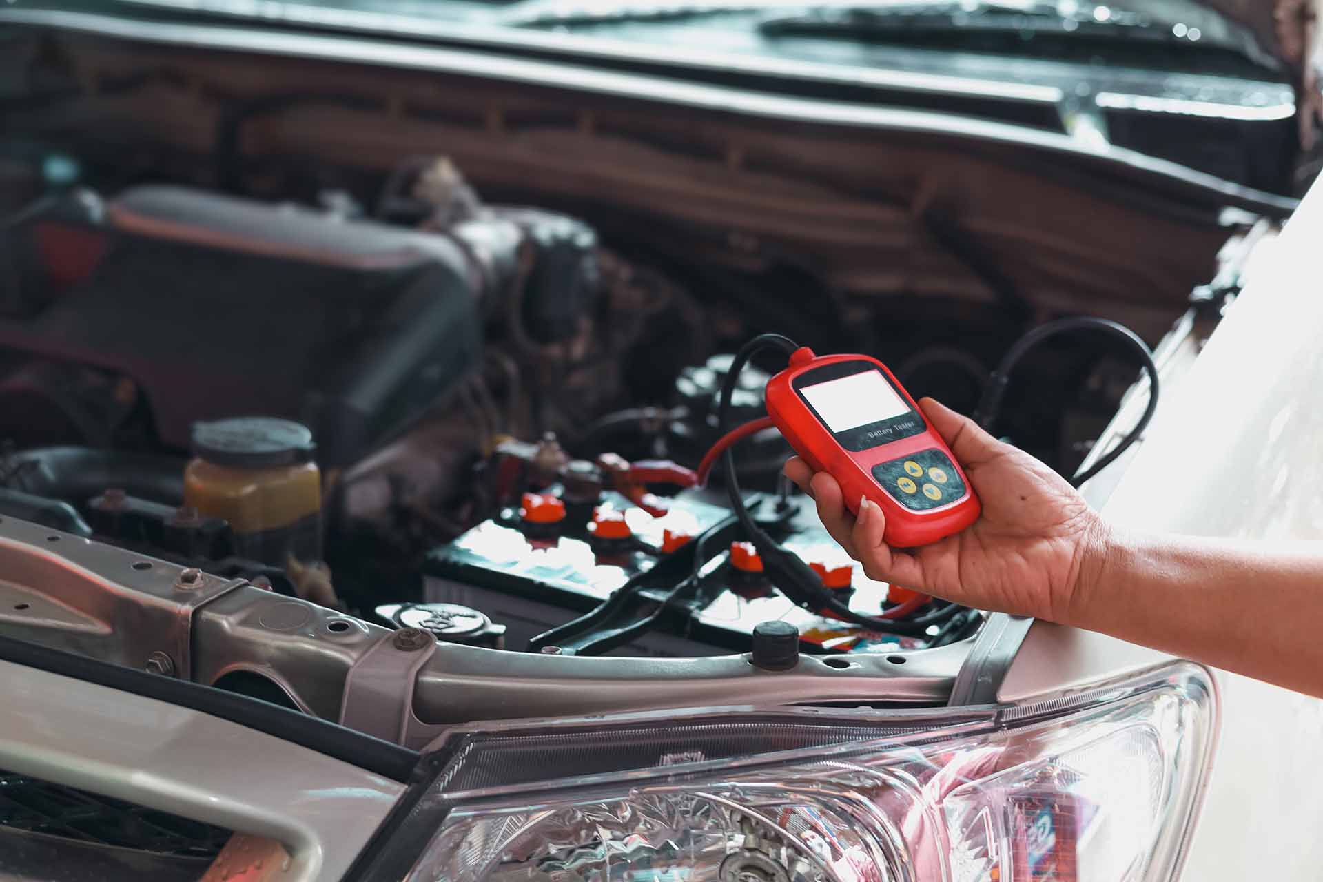 a mechanic testing a car battery voltage